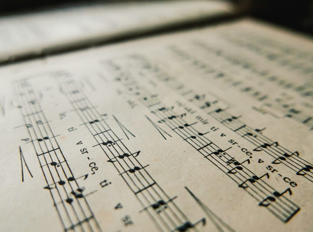 Close-up image of An old book with music notes. Sheet music with notes and lyrics