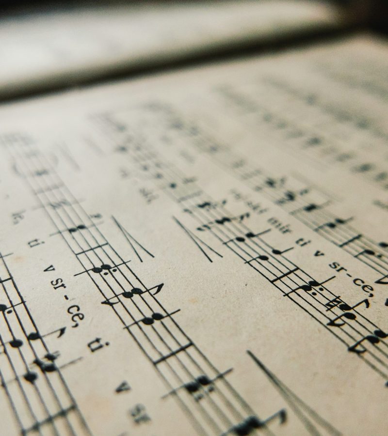 Close-up image of An old book with music notes. Sheet music with notes and lyrics